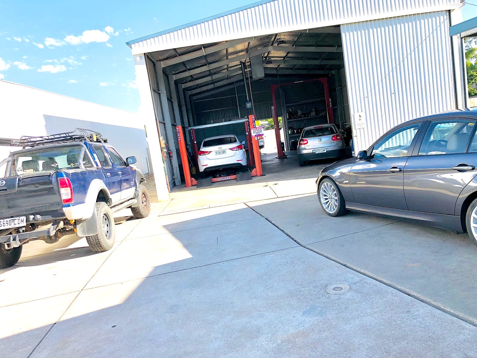 Inside the Adelaide Motor Garage workshop with cars up on hoists
